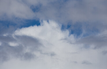 Fluffy clouds cover the summer blue sky
