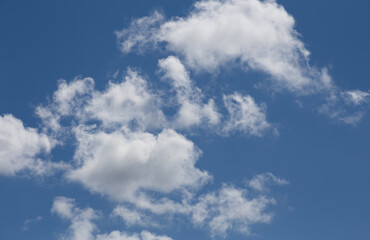 Fluffy clouds cover the summer blue sky