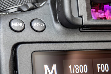 The back of digital camera with Menu and Info buttons above display, close up.