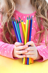 The girl holds colored pencils. Back to school concept. 