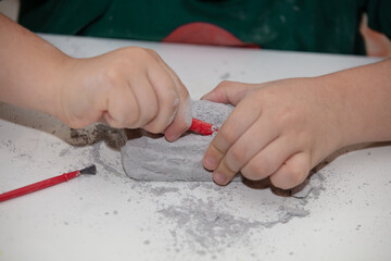 image of an educational game to find fossils for a small archaeologist, with children's hands digging