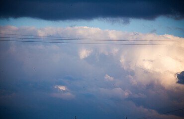 Fluffy clouds cover the summer blue sky