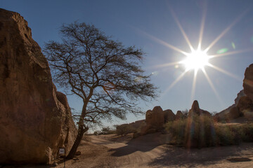 Fototapeta na wymiar Sunburst on giant rocks in desert