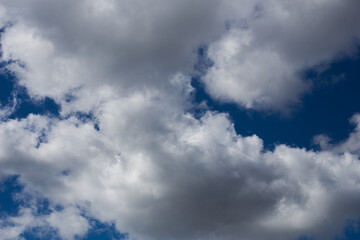 Fluffy clouds cover the summer blue sky