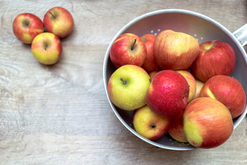 Ripe red apples in metallic bowl on wooden table with copy space for text. close up of fresh fruits concept, vitamin fruits background, banner
