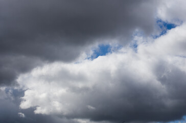 Fluffy clouds cover the summer blue sky