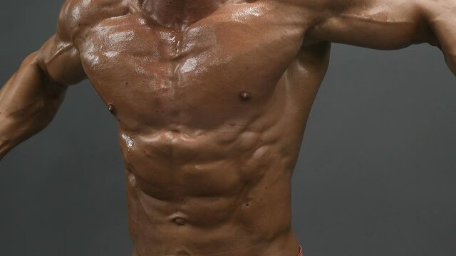 Bodybuilder handsome strong athletic good looking man pumping up chest muscles workout fitness and bodybuilding healthy concept - muscular fitness men doing pectorals exercises in gym naked torso
