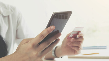 Online payment,Young Woman's hands using smartphone and hand holding credit card for online shopping.