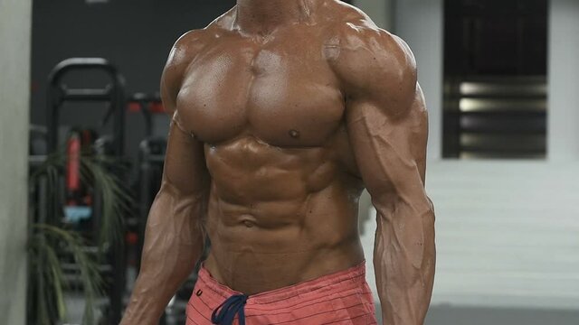 Bodybuilder handsome strong athletic rough man pumping up muscles biceps workout fitness and bodybuilding healthy concept background - muscular fitness men doing arms exercises in gym naked torso
