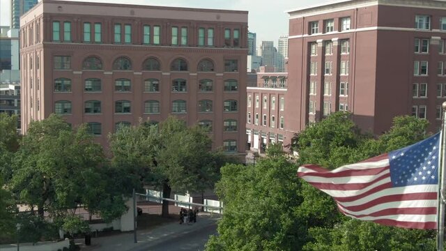 Aerial: USA Flag in Dealey Plaza where President JFK was assassinated. Texas, USA
