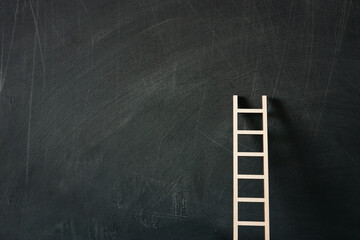 wooden ladder over classroom blackboard background