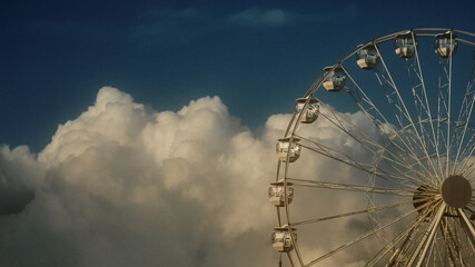 ferris wheel against blue sky and clouds