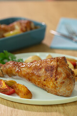 Roasted chicken legs with potato and tomatoes