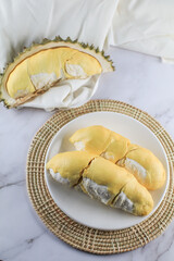 Close up durian the king of fruit in Thailand on white plate.Summer tropical Thai traditional fruits so delicious,spiky peel,sweet and good smell. Ripe durian has been peel yellow gold color.