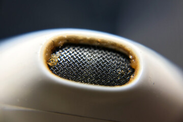 White earphones is very dirty with yellow earwax, macro image, close up macro of headphones