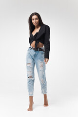 Young cool hipster girl in black shirt and blue banana jeans on white background