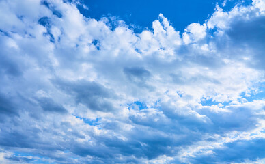 Blue sky background with white clouds on a sunny day.