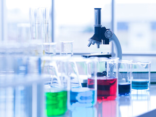 Selective focus on microscope in the science lab with many beakers full of liquids. Sample for...