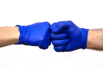 hands in blue protective surgical gloves greet each other with their fists.