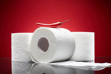 Red chili pepper on the top toilet papers like pain symbol from hemorrhoid or menstruation symptom...