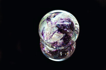 decorative glass sphere and reflection against black