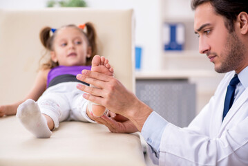 Fototapeta premium Small girl visiting young male doctor