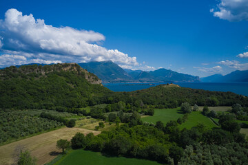 Fototapeta na wymiar Lake Garda, Italy. Aerial view of rocca di manerba in the background alpine mountains garda island and Lacuale Park