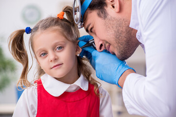 Small girl visiting young male doctor otorhinolaryngologist