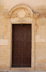 Fototapeta na wymiar The door of the 18th century Basilica San Niccolo dei Greci in the southern Italian city of Lecce 