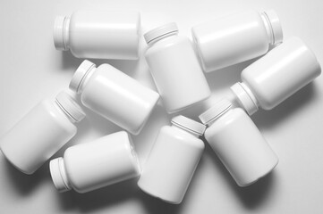 nine white plastic containers for pills and healthy food. Flatlay. Isolated on white background.