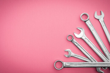 Repair tool. Metal wrenches on a pink background.