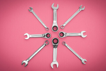 Repair tool. Metal wrenches on a pink background.