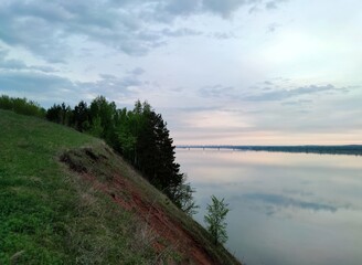 Obraz premium morning on top of a wooded slope near the river against a beautiful sky at dawn