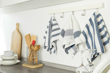 Different kitchen towels hanging on hook rack indoors