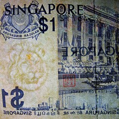 Macro photo of a Singapore one dollar bill (back side). Featuring a lion watermark and blue ink govt building. This series of bills was discontinued in 1987.