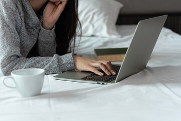 Women in sporty pajamas lay down chat online with friends or shopping online. And relax in bed on holiday.