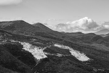 Black and white panoramic view of an open quarry, Xanthi region, Northern Greece, close to the gorge of river Nestos. Impressive clouds in the late autumn Greek sky