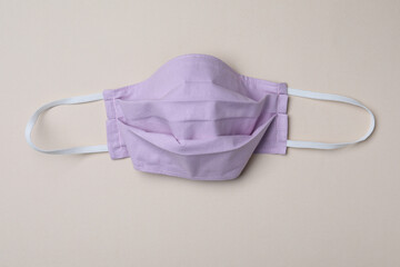 Homemade protective mask on beige background, top view. Sewing idea