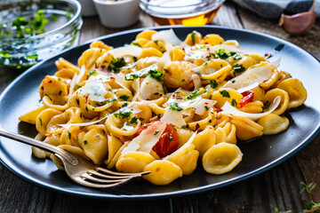 Pasta with parmesan and vegetables on wooden background
