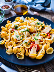 Pasta with parmesan and vegetables on wooden background
