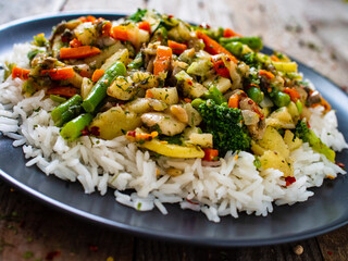 Roast meat, white rice and vegetables on wooden table
