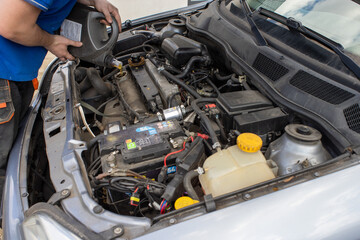 Fototapeta premium The person changes the oil filter in the car