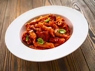 Penne with meat, tomato sauce and vegetables on white background
