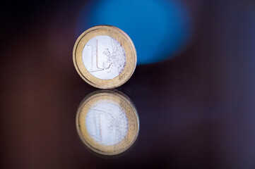 one euro coin reflected on a colored background