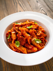 Penne with meat, tomato sauce and vegetables on white background
