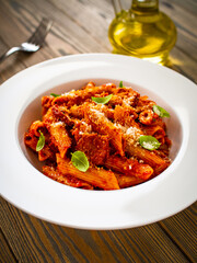 Penne with meat, tomato sauce and vegetables on white background
