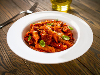 Penne with meat, tomato sauce and vegetables on white background
