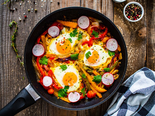 Shakshuka - fried eggs with vegetables in frying pan
