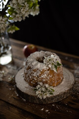 Rustic style apple bundt cake with powdered sugar on old wooden table