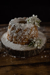 Rustic style apple bundt cake with powdered sugar on old wooden table